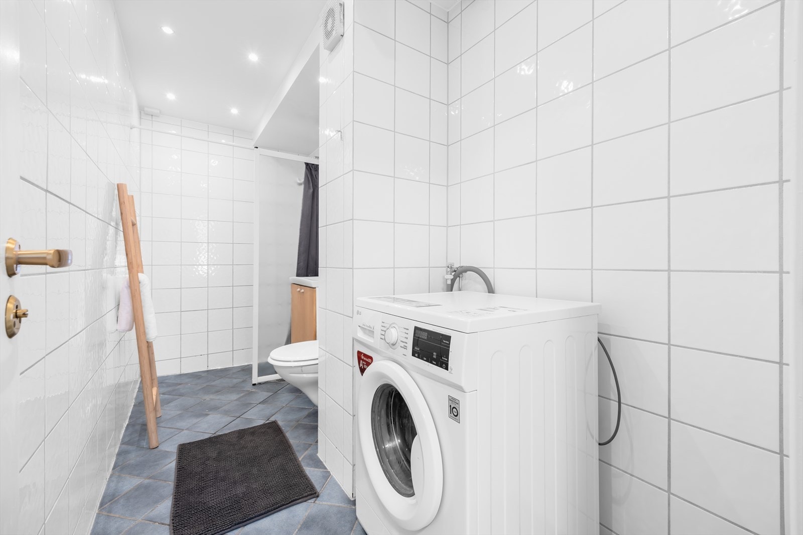 Flott flislagt bad med varmekabler og opplegg for vaskemaskin. Galleribilde