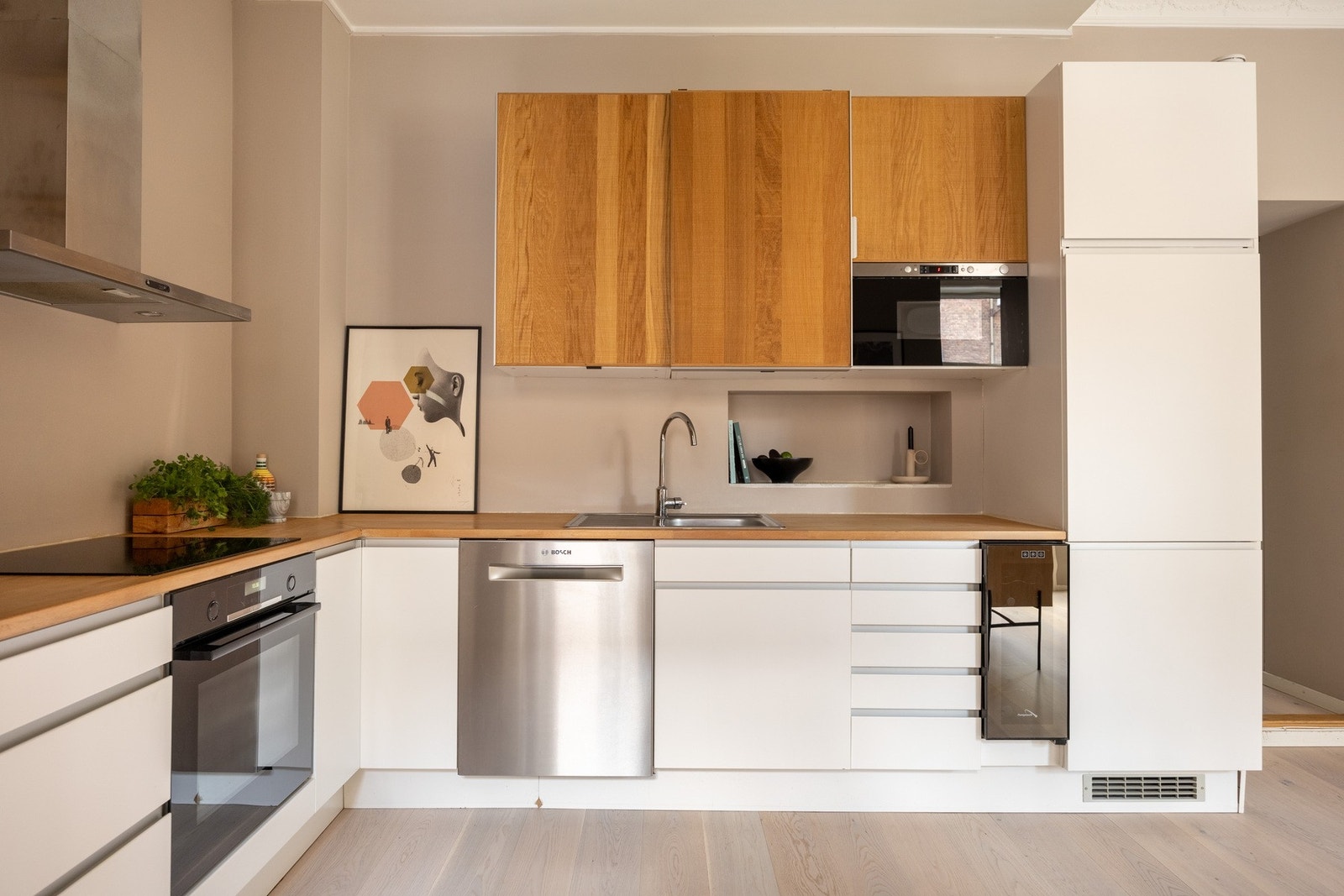 Integrerte hvitevarer gir kjøkkenet et godt helhetsinntrykk, og består av kjøleskap med fryserdel, oppvaskmaskin, samt komfyr med nedfelt induksjonstopp. Galleribilde