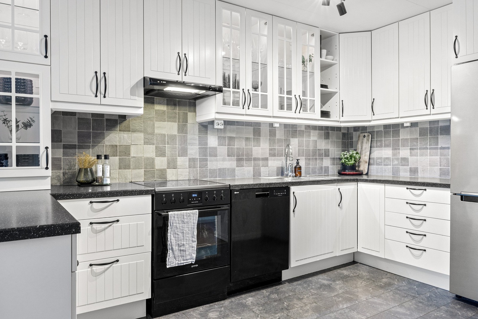 Pen og klassisk innredning med takhøye overskap for maksimal lagringsplass Galleribilde