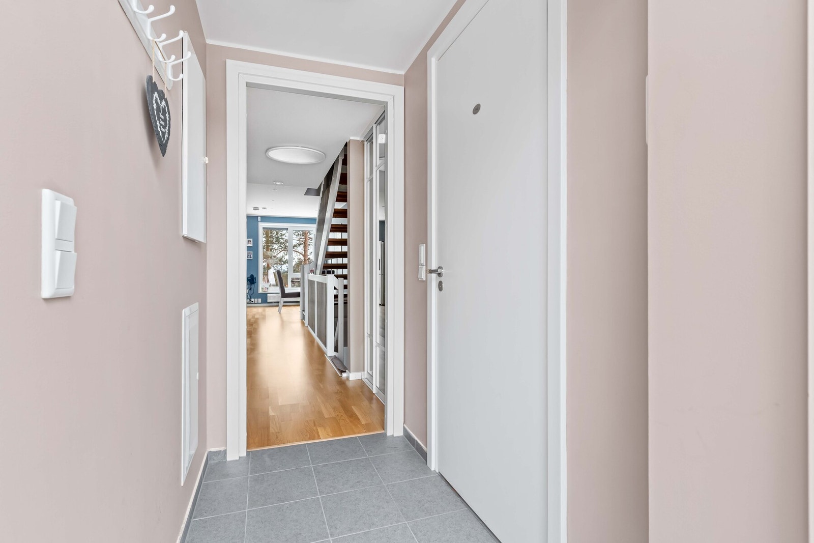 Et lyst inngangsparti inviterer alle besøkende inn i en familievennlig bolig. Galleribilde