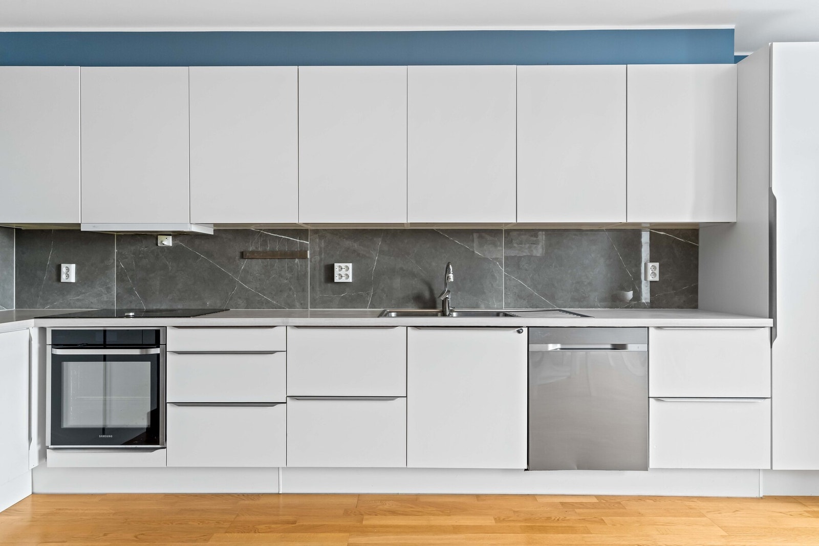 Kjøkkeninnredning med glatte, folierte fronter og benkeplate i laminat. Galleribilde