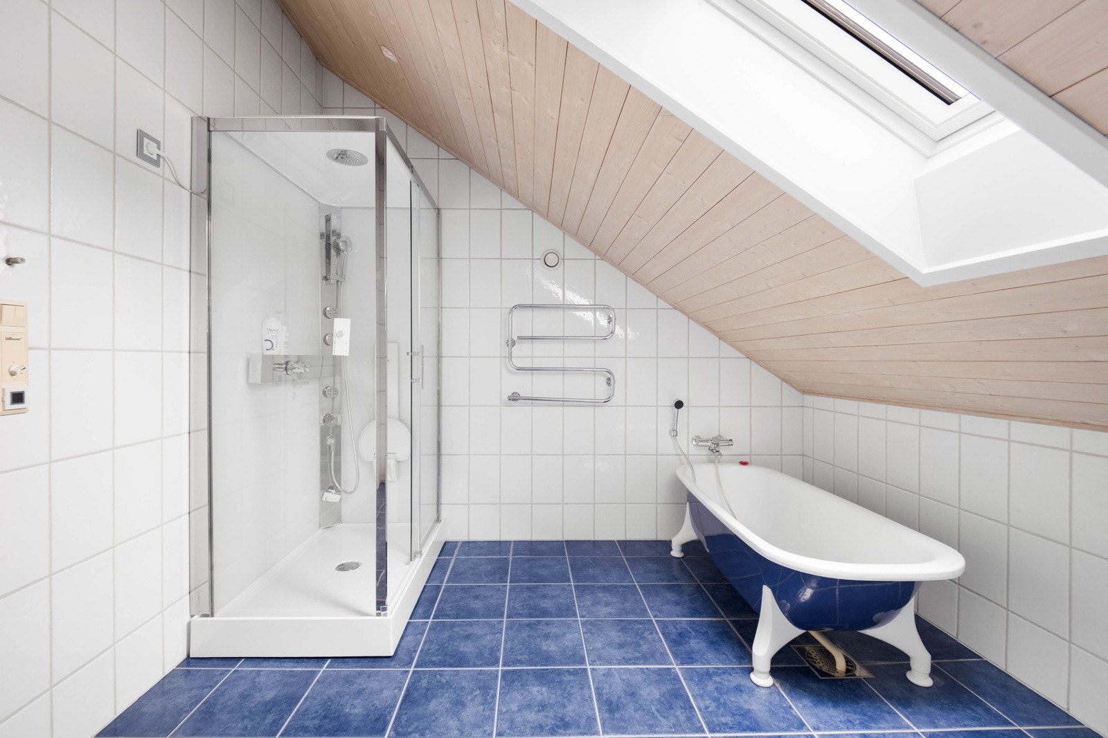 Badet er helfliset med panelhimling, downlights, gulvvarme og friskt overlys fra et takvindu. Galleribilde