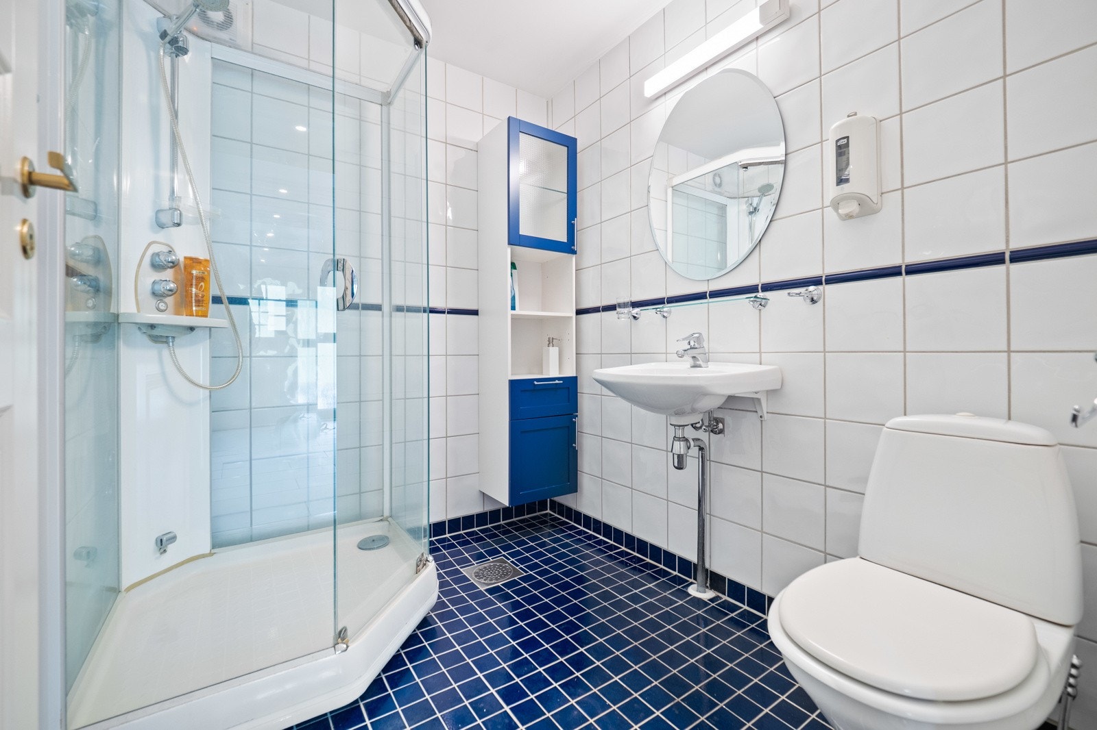 Badet i kjelleren er helfliset med gulvvarme og smart innredet med et dusjkabinett. Galleribilde