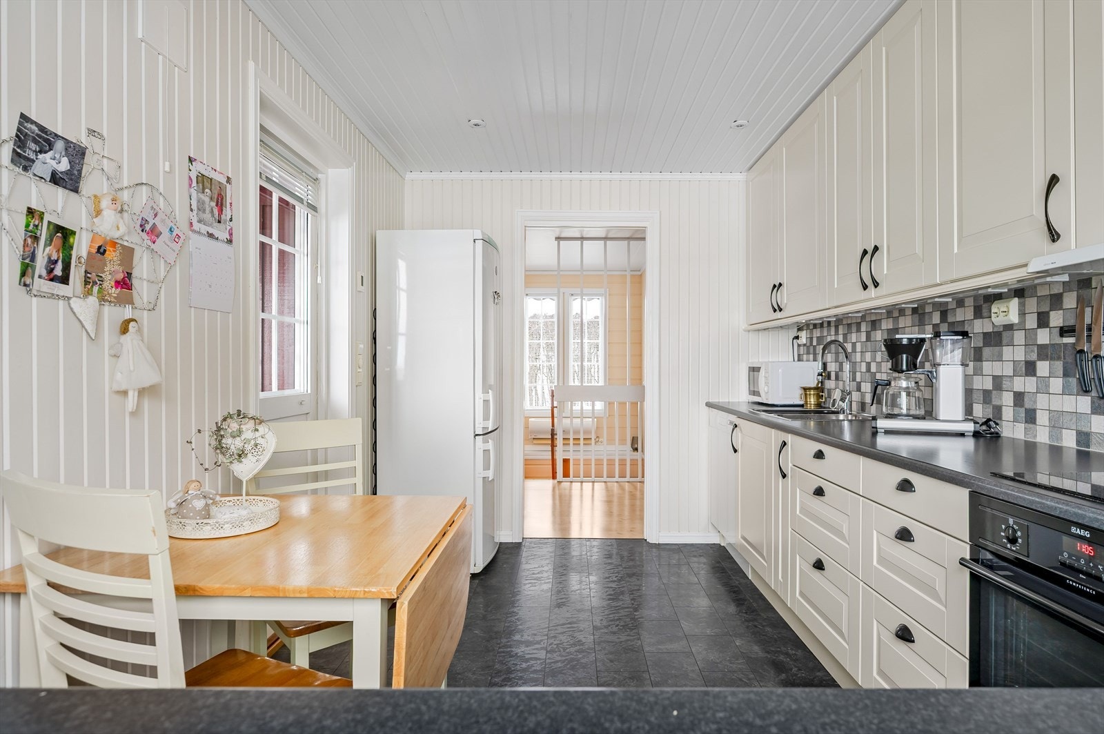 Kjøkkenet er oppgradert i 2012. Du har god skap- og benkeplass i innredningen som har lyse profilerte fronter og laminert benkeplate med nedfelt oppvaskkum. Praktisk med fliser i benkeryggen og belysning under de takhøye overskapene. Galleribilde