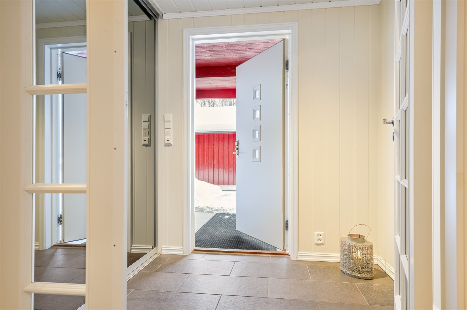 Du ønskes velkommen inn i et lyst og praktisk vindfang med god oppbevaringsplass i stor plassbygget skyvedørsgarderobe. Det gjøres oppmerksom på at vindfanget ikke er godkjent for varig opphold. Galleribilde