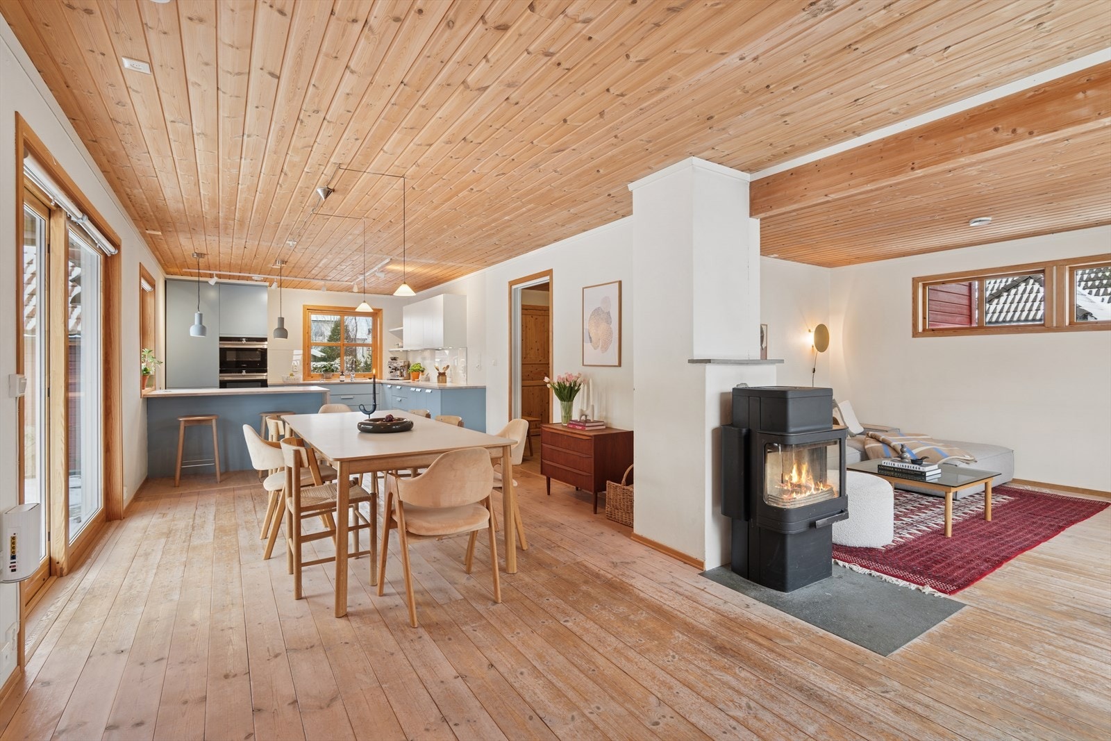 Vinkelformet stue med store vindusflater og sjarmerende furugulv. Galleribilde