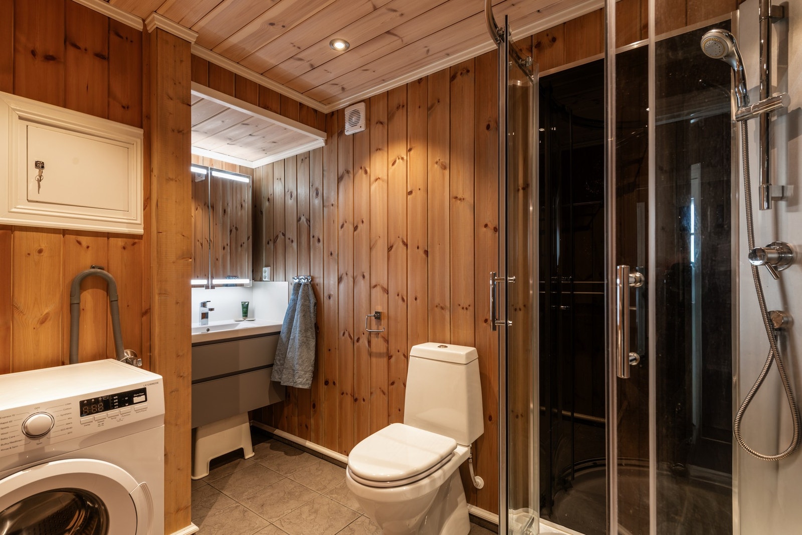 Badet har fliser med varmekabler på gulv, og trepanel på vegg og i himling. Galleribilde