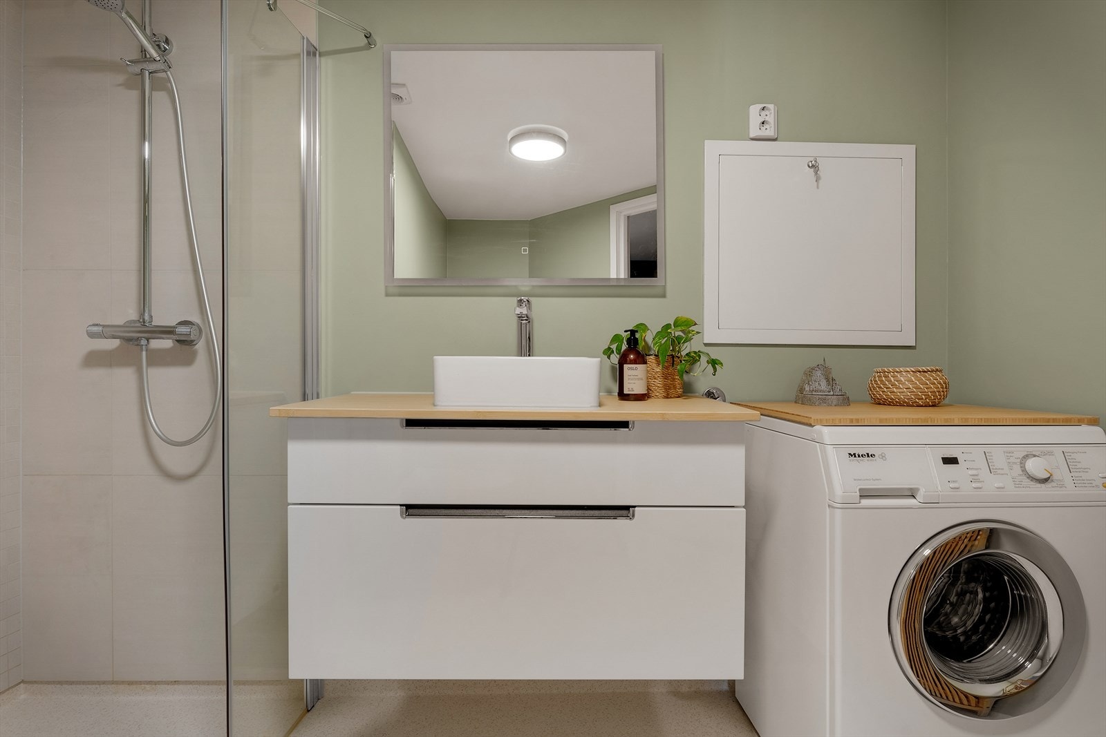 Pent og praktisk innredet; dusj med foldedør, skuffeseksjon under servant, speil med belysning. Galleribilde