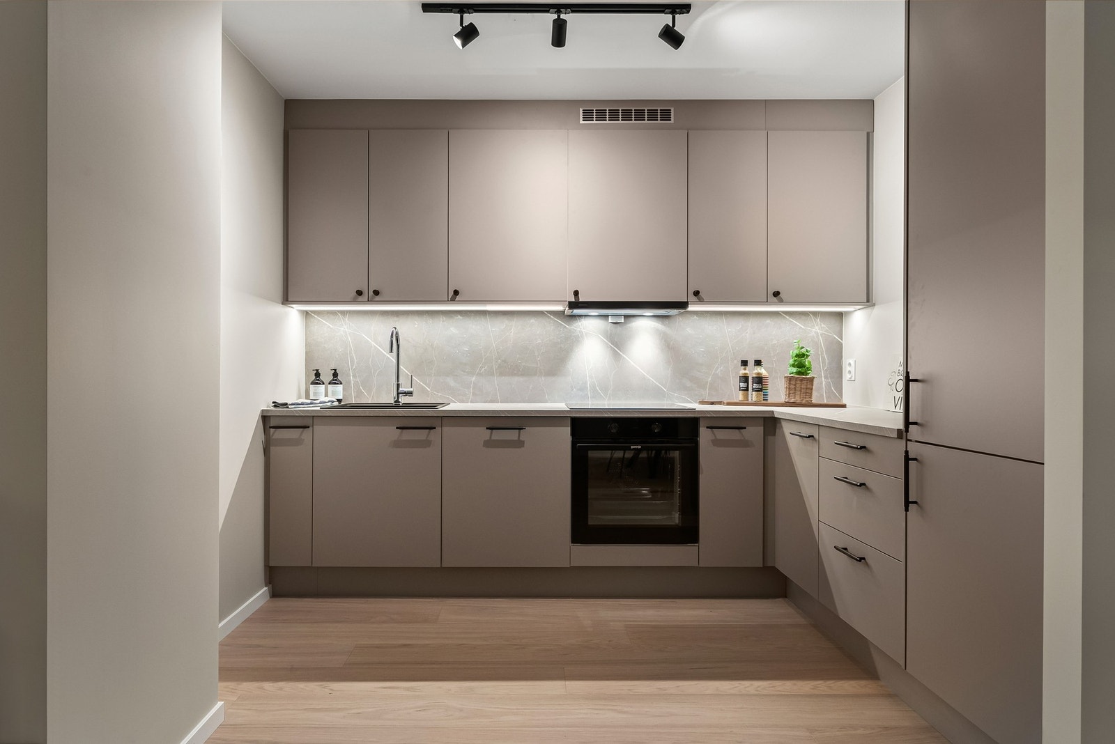 Lekkert og stilrent HTH-kjøkken. Her er alle hvitevarer integrert - stekeovn, oppvaskmaskin, kjøl/frys og platetopp, samt ventilator fra Røroshetta med kullfilter. Galleribilde