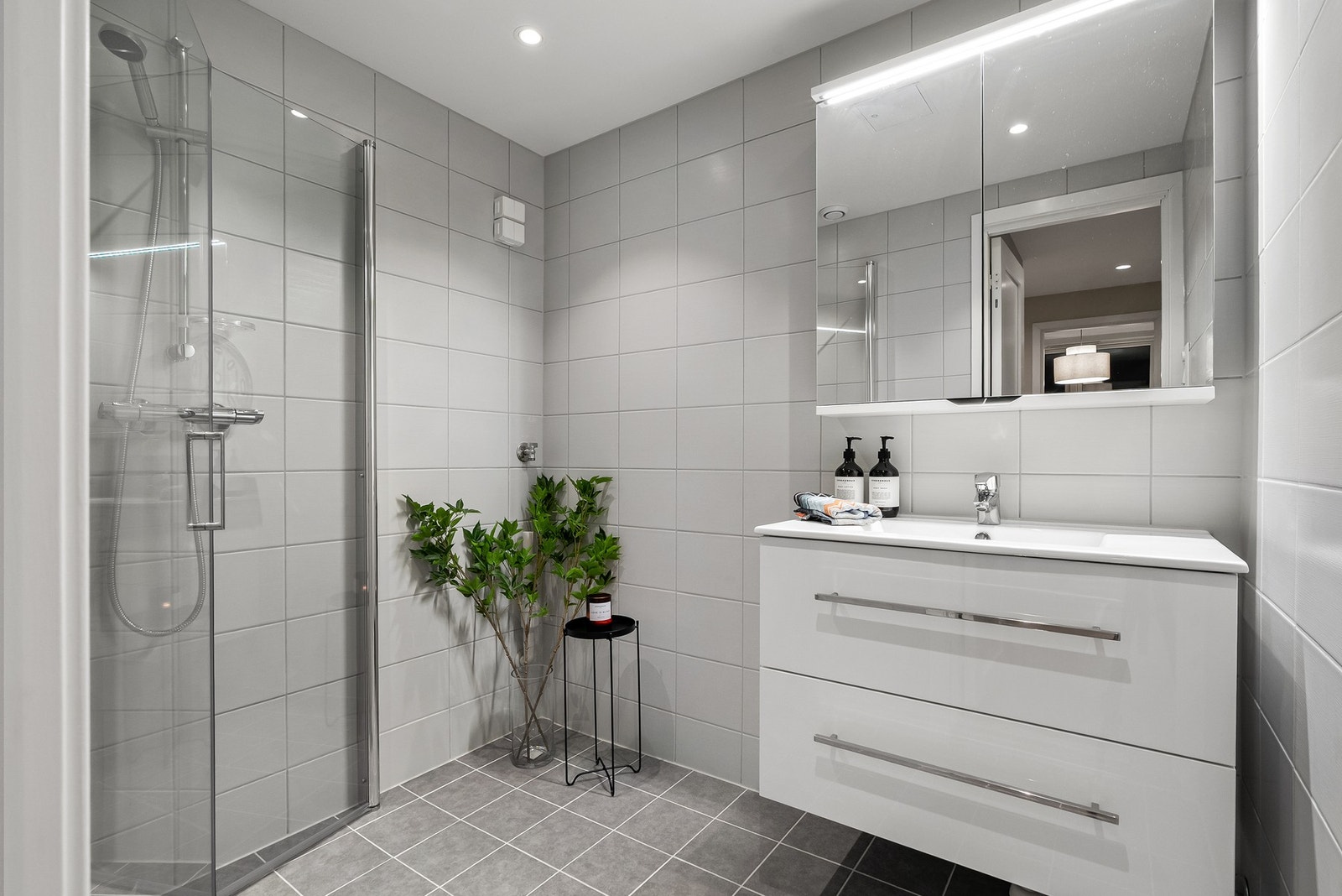 Badet ble totalrehabilitert i regi av borettslaget i 2021. I hjørnet er det opplegg for vaskemaskin. Galleribilde