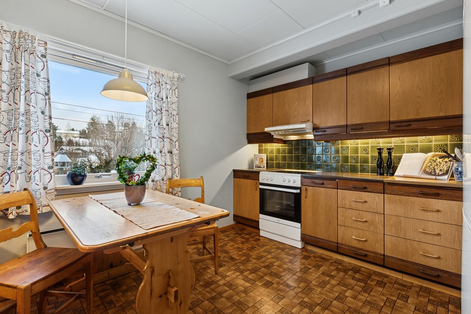 Romslig kjøkken med rom for egen spiseplass ved kjøkkenvinduet. Galleribilde