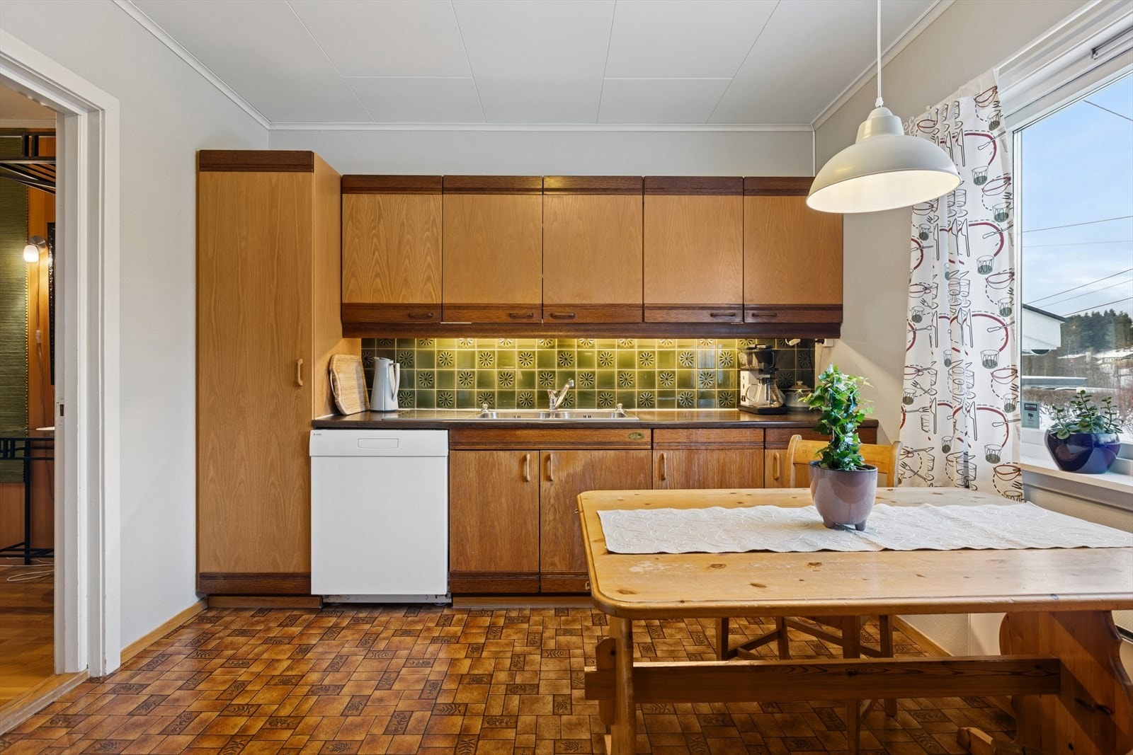 Kjøkkenet har en eldre, to-sidet innredning med glatte fronter med laminert benkeplate. Galleribilde