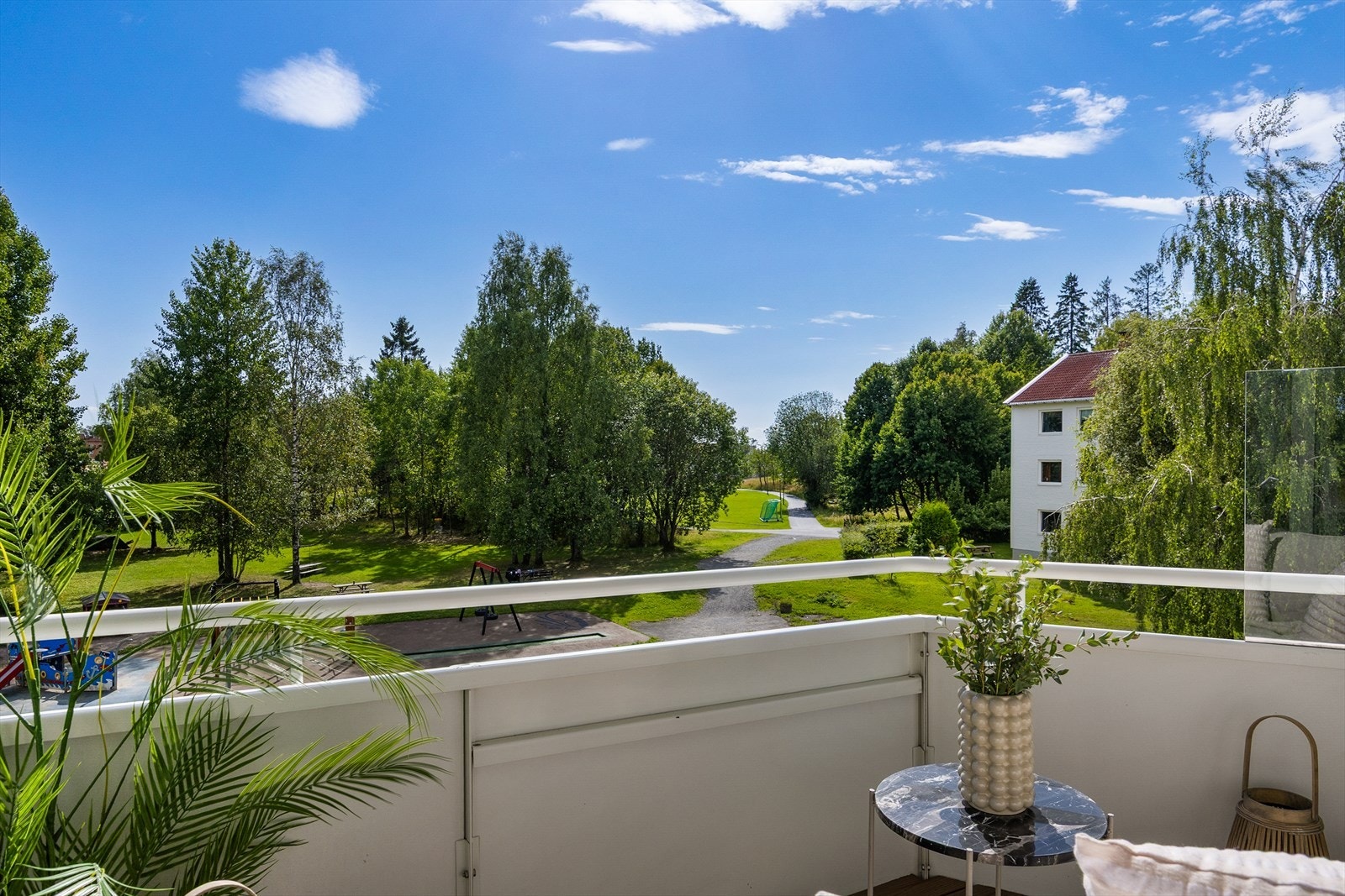 Fra balkongen har man en åpen og grønn utsikt over pent opparbeidede fellesområder med trær og gressplen. Beliggenheten gir en luftig romfølelse og et fredelig preg, godt skjermet fra trafikk og støy. Galleribilde