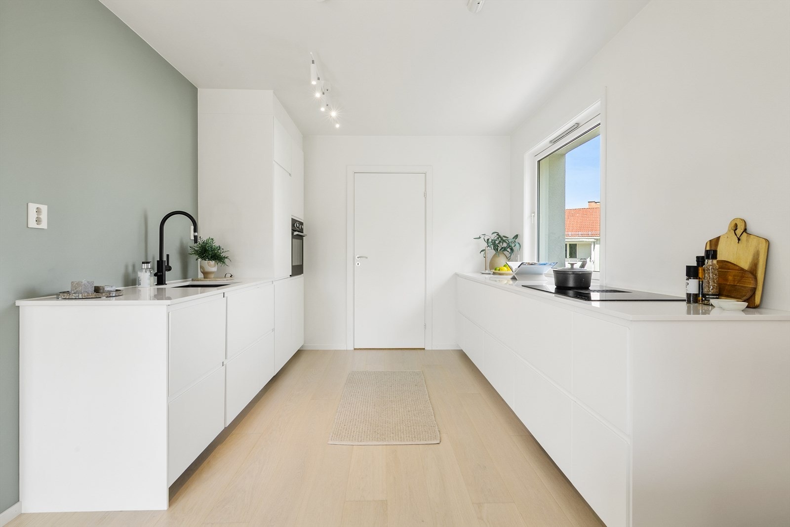 Kjøkkenet fremstår moderne og stilrent med slette, hvite fronter og rene linjer som gir et ryddig og helhetlig uttrykk. Den langstrakte løsningen gir god arbeidsflyt samt rikelig med skap- og benkeplass. Galleribilde