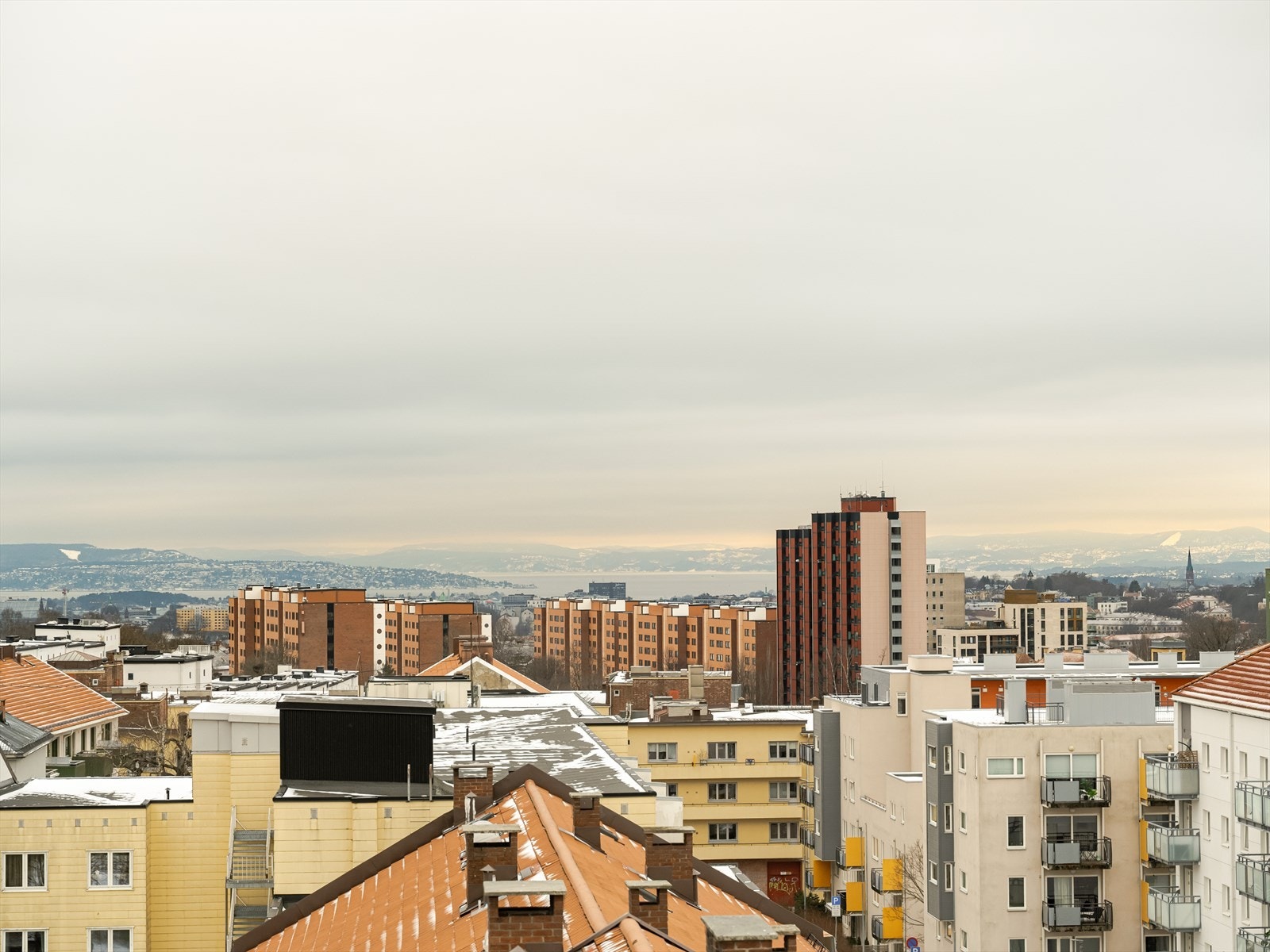 Panorama over bylandskapet med høyhus og boligblokker i horisonten. Galleribilde