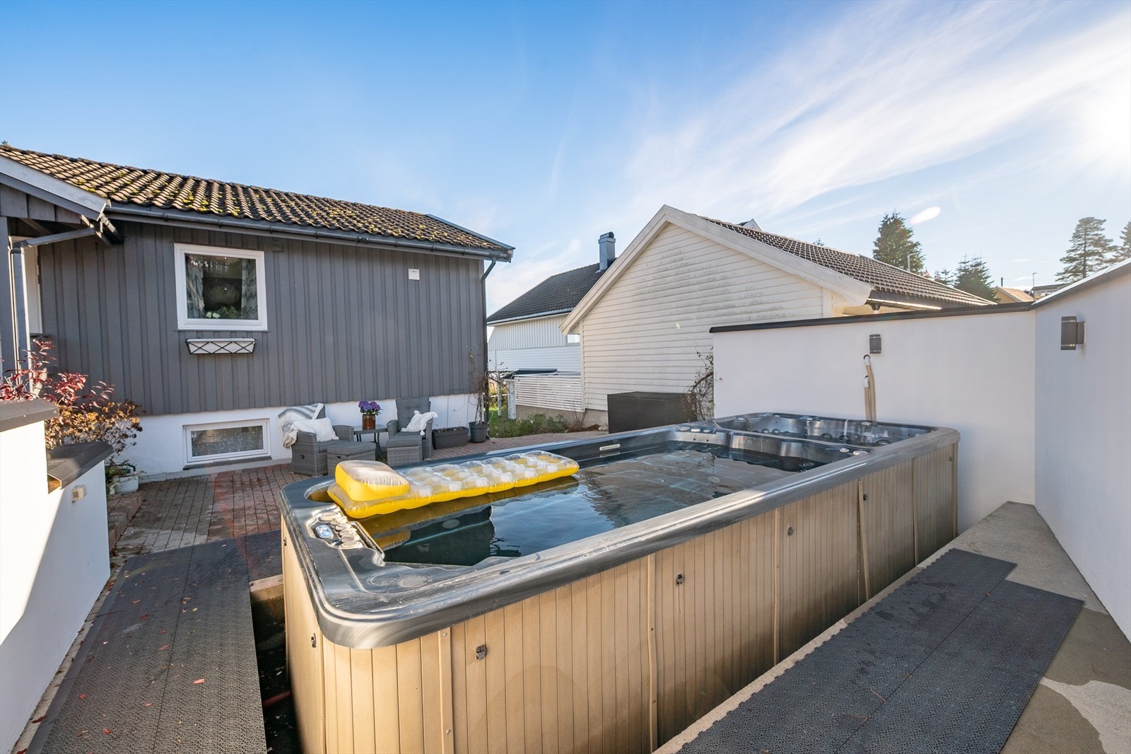 Skjermet område rundt basseng og stenlagte oppholdsareal like ved. Galleribilde