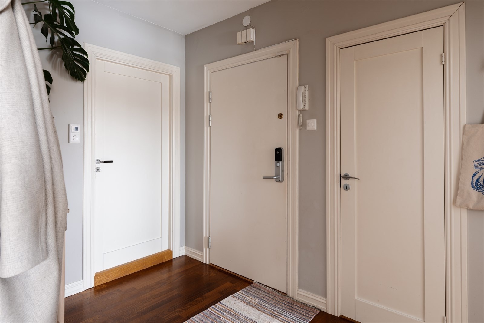 Velkommen inn i en lys entré. Inngangsdøren er utstyrt med elektronisk dørlås og porttelefon. Galleribilde