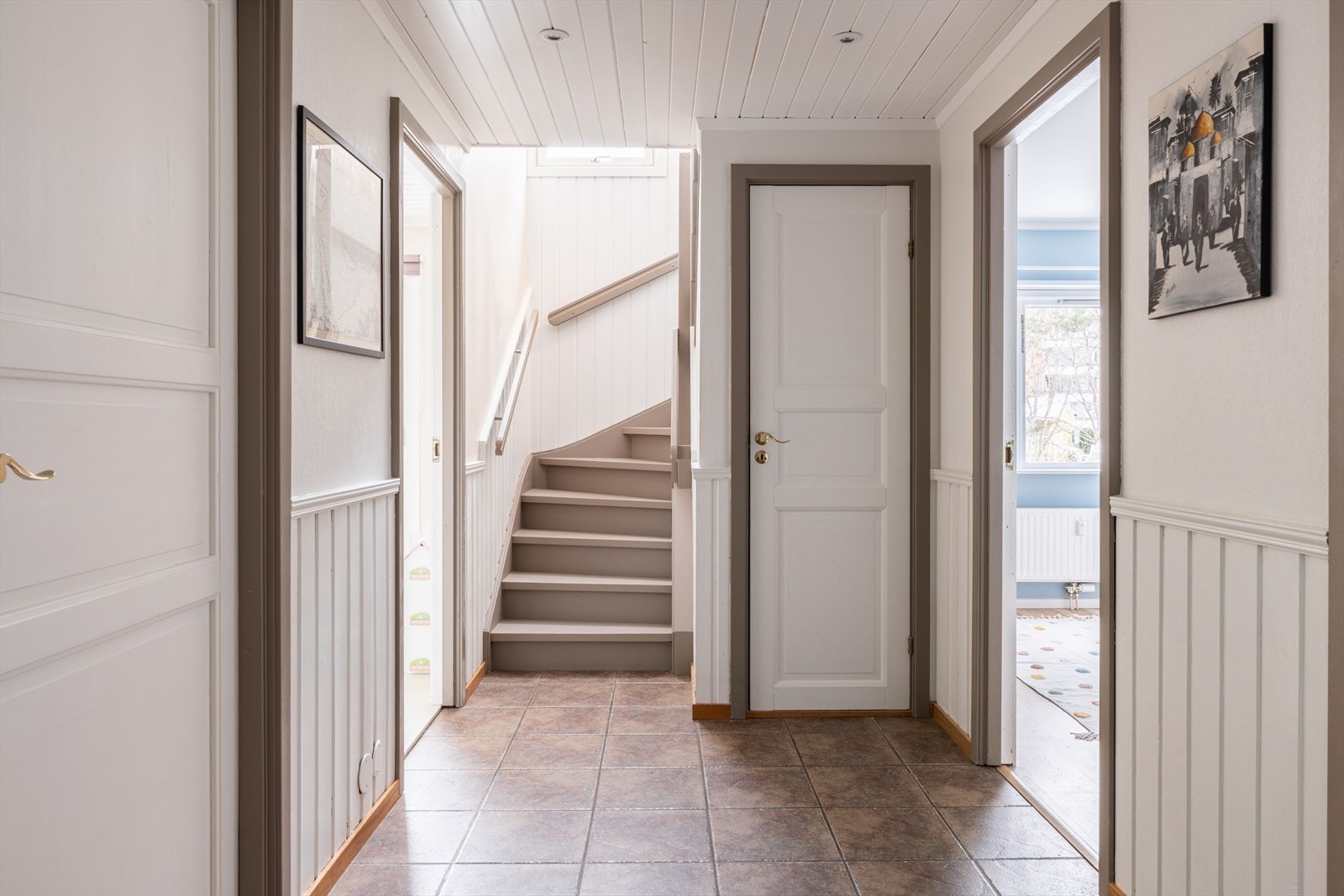 Gangen med downlights binder rommene sammen, og den nymalte trappen leder opp til andre etasje. Galleribilde