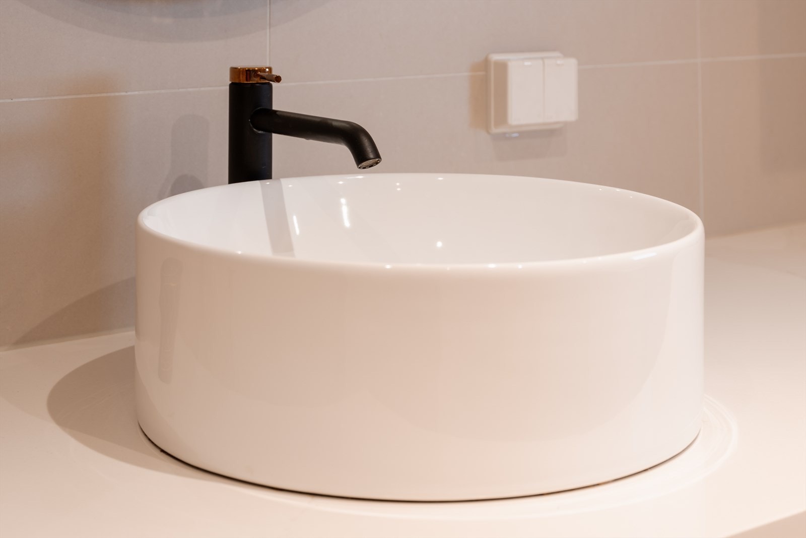 Detaljer som den runde servanten og ettgreps kranen understreker den gjennomførte stilen. Galleribilde