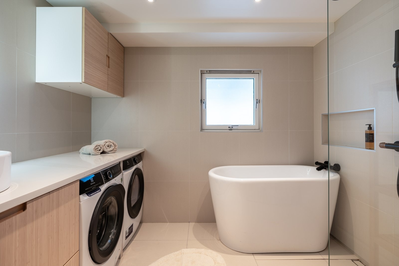 Svært delikat baderom med både badekar og dusj, samt praktisk opplegg for vaskesøyle under benkeplaten. Galleribilde