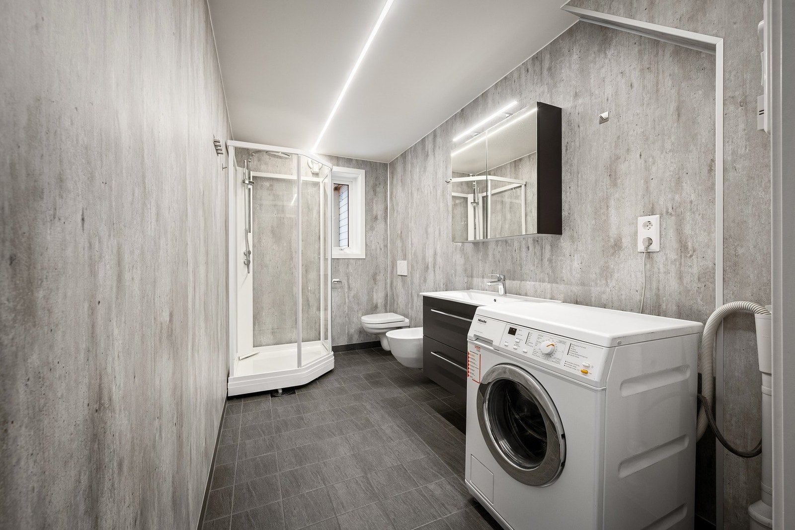 Innredet med toalett, servant, dusjkabinett og røropplegg for vaskemaskin Galleribilde