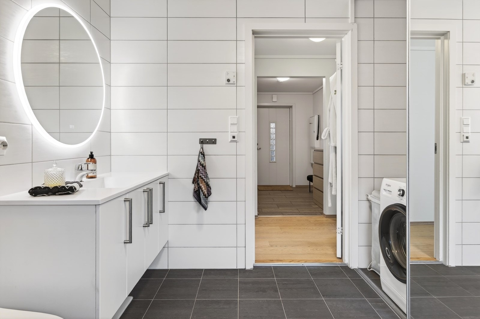 Praktisk skyvedørsgarderobe skjuler vaskeromsdelen på en elegant måte Galleribilde