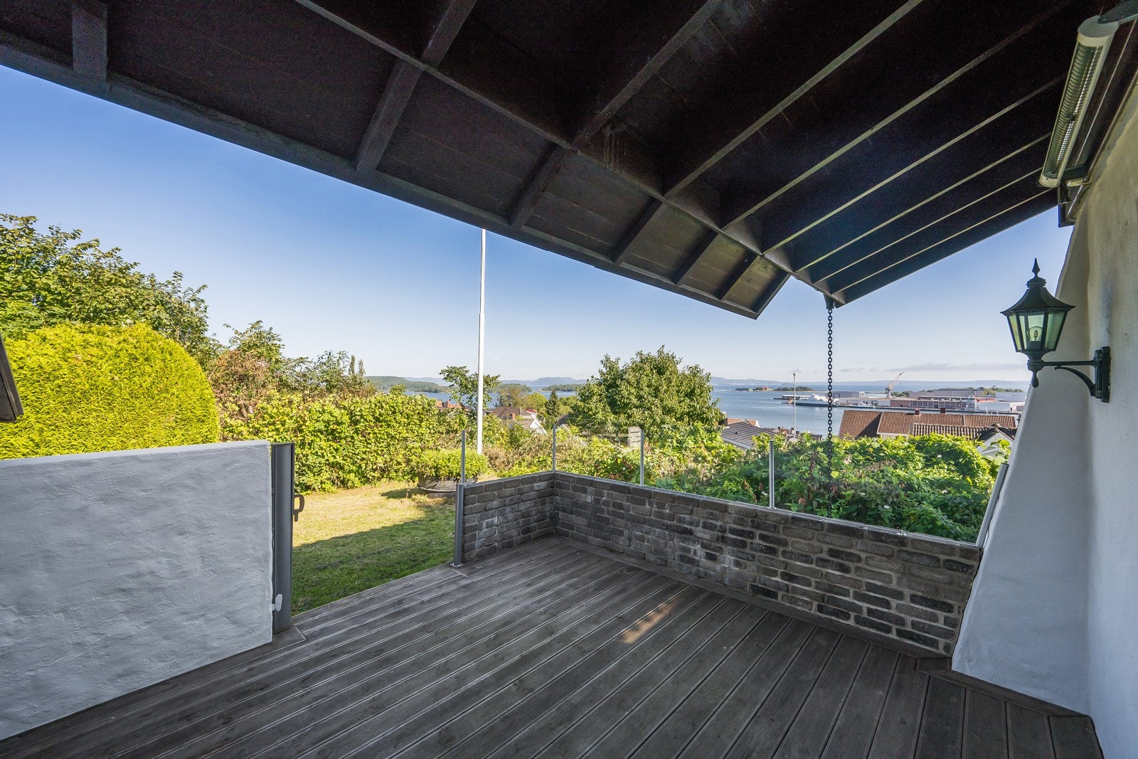 Overbygget og lun terrasse som fortsetter ut i hagen Galleribilde