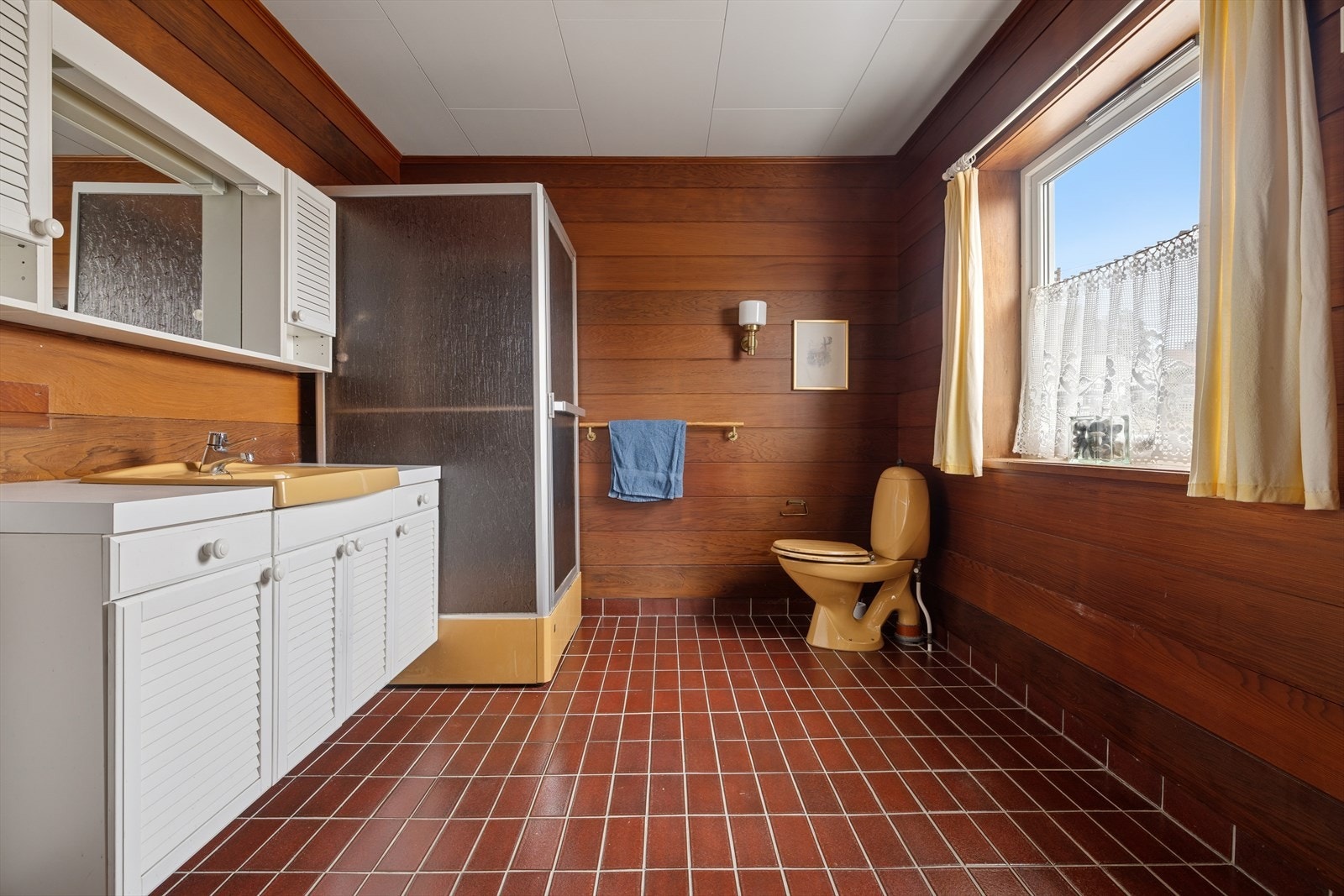 Badet har i all hovedsak standard fra 1979. Det er flislagt gulv og varmekabler Galleribilde