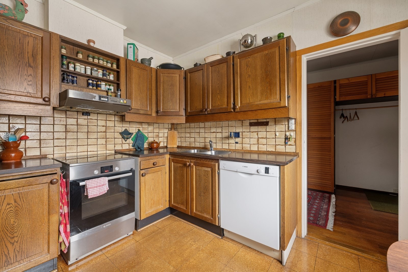 Kjøkkenet er godt utnyttet med over- og underskap. Frittstående hvitevarer. Galleribilde