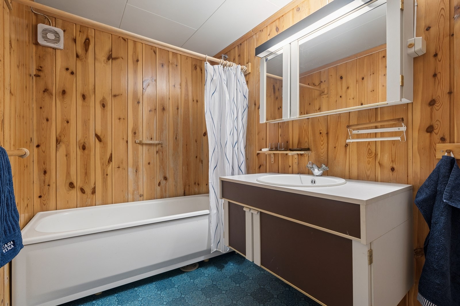 Bad med badekar og servant i kjelleren. Badet er av eldre dato. Galleribilde