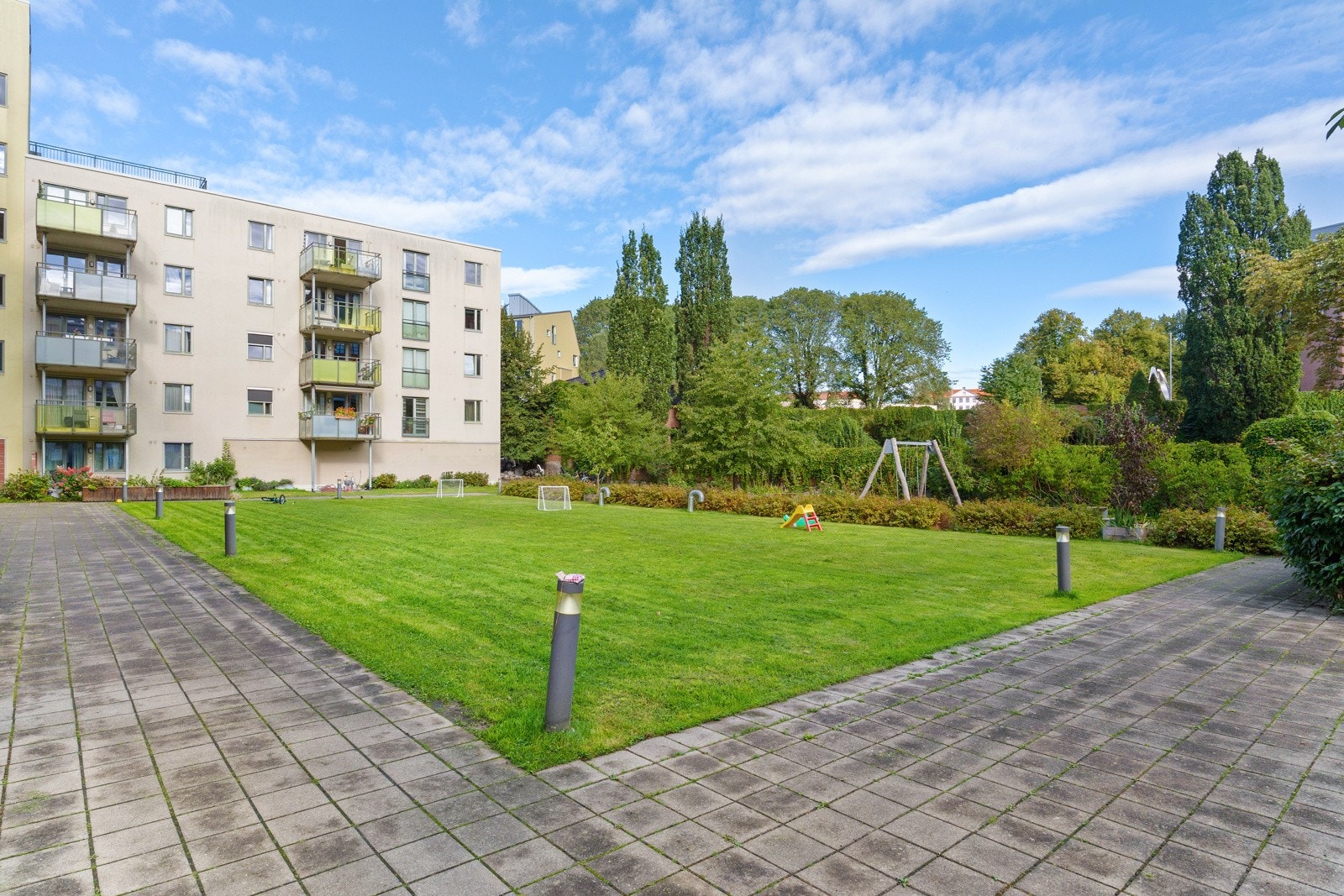 Egen mini park med stor plen, fin beplantning og annet bak kvartalets låste porter Galleribilde