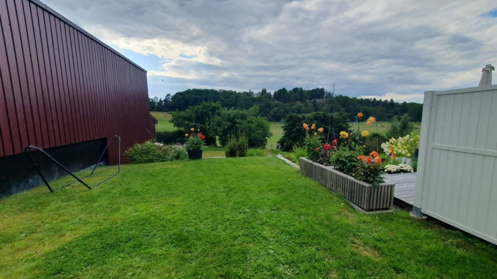 Sommerbilder (sommerbilder er selgers egne). Hagen har en frodig plen og en beplantning som gir både liv og farge til uterommet. Galleribilde