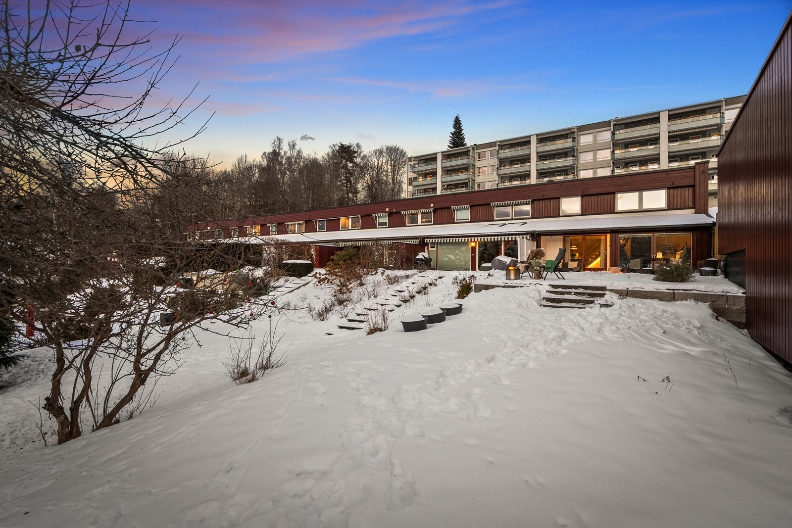 Rekkehuset disponerer en stor hage som har en frodig plen og en beplantning som gir både liv og farge til uterommet. Galleribilde