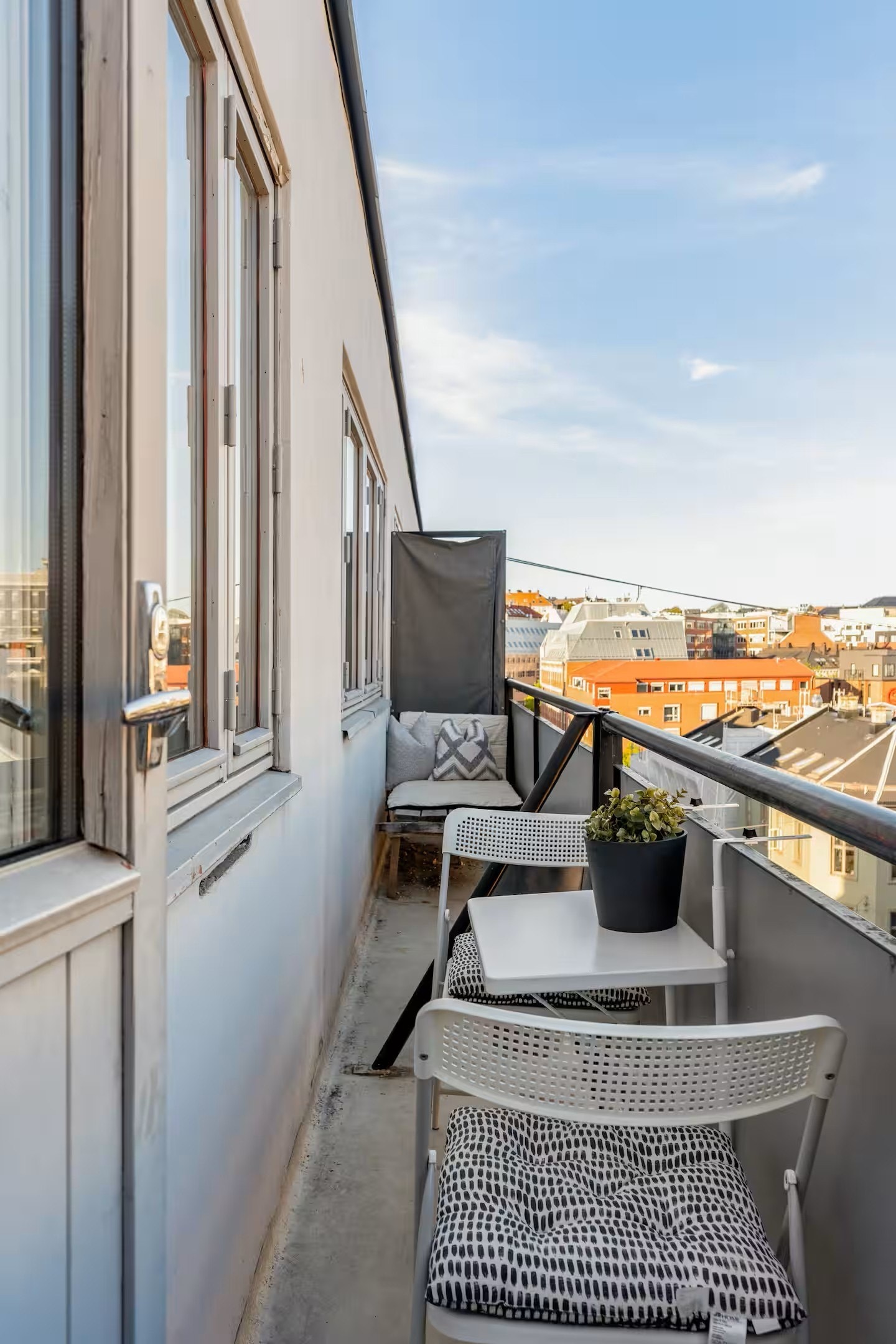 Brannbalkong med gode solforhold, utstyrt med solseng og cafébord Galleribilde