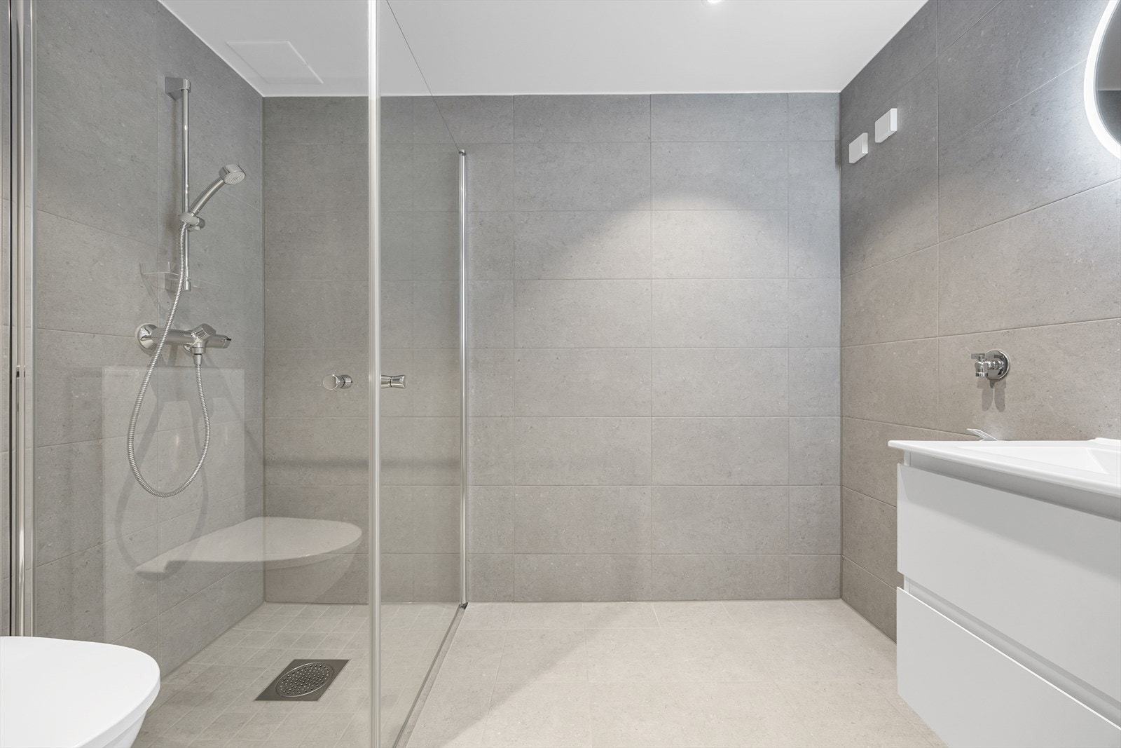 Dusjhjørne med innfellbare glassdører og behagelige varmekabler i gulvet. Galleribilde