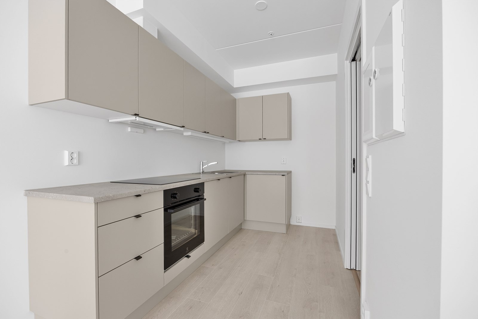 Kjøkkeninnredningen har slette, lyse fronter og en slitesterk laminatbenkeplate. Galleribilde