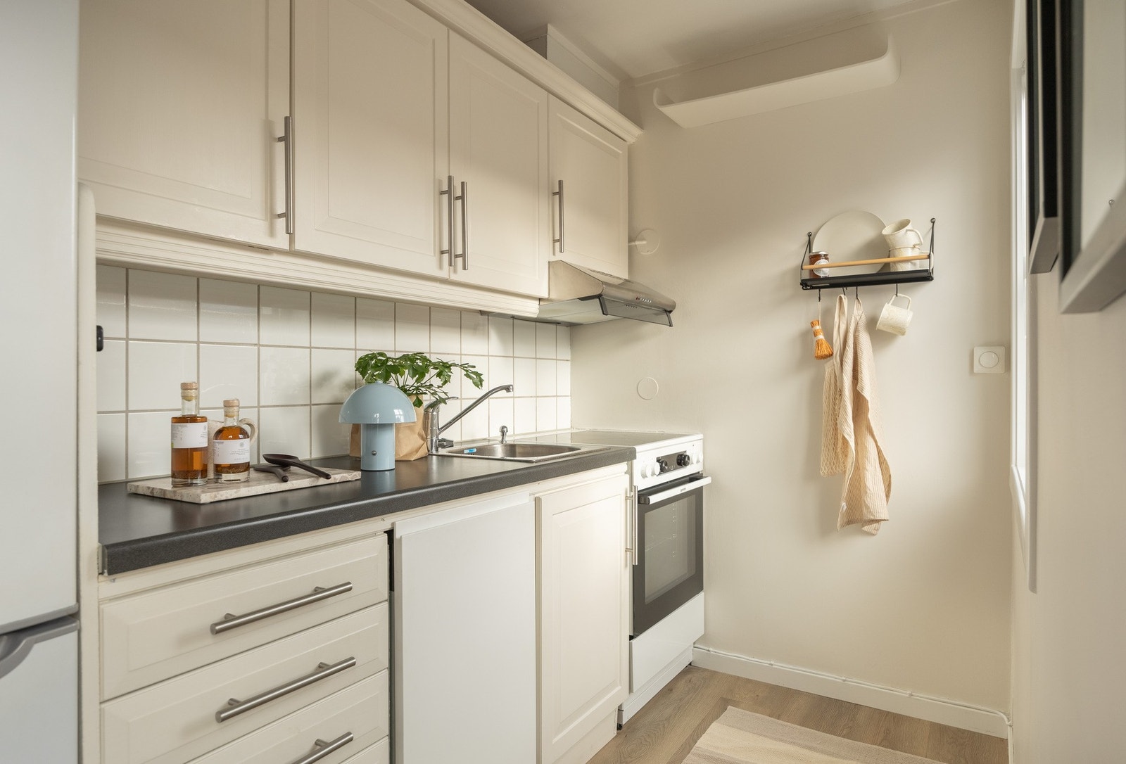 Nyere oppvaskmaskin og komfyr fra 2023. Kjøkkeninnredningen er malt i samme farge som veggflatene. Galleribilde