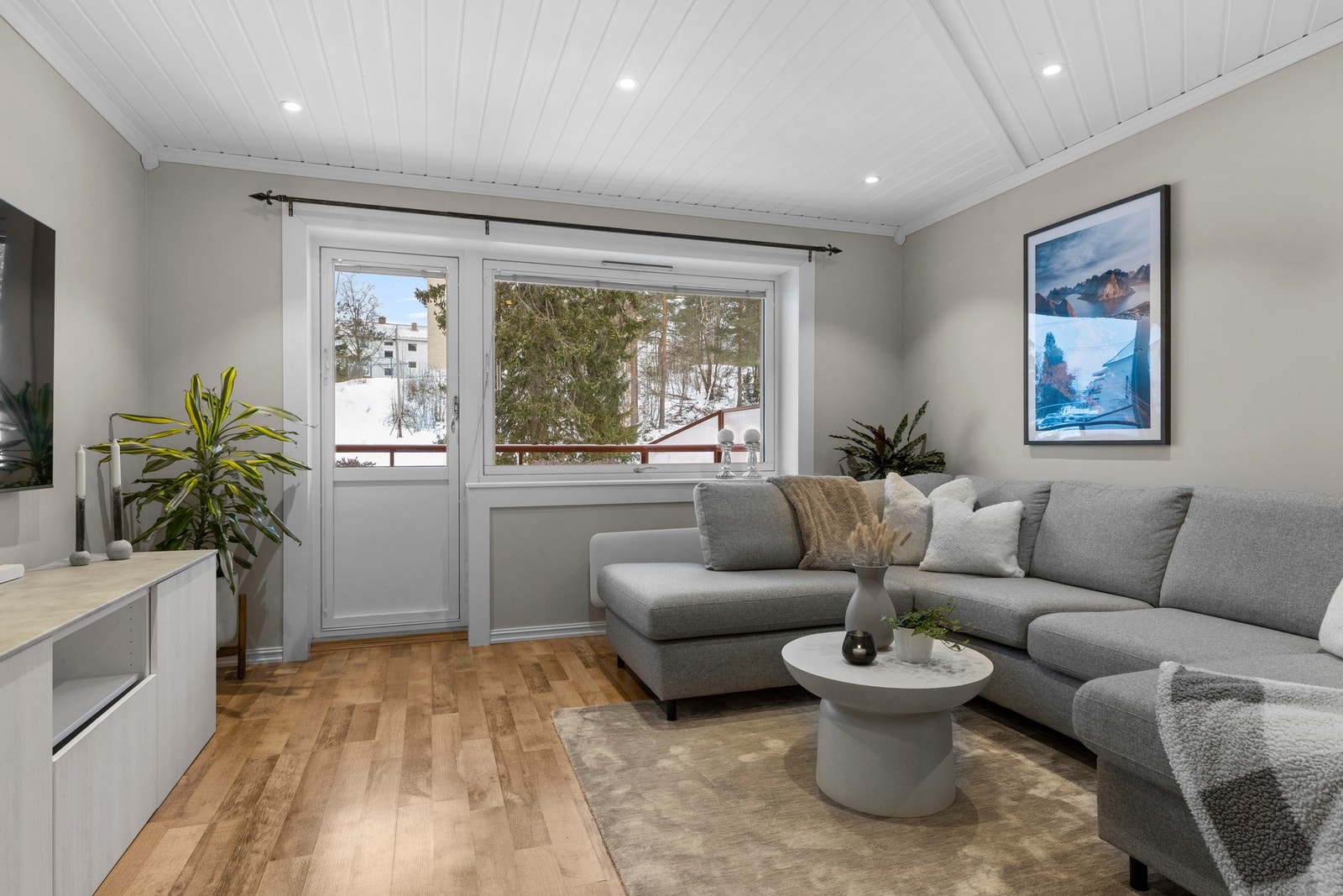 Store vinduer og balkongdør fra 2011 gir et lyst uttrykk, med hvite vinduskarmer som rammer inn rommet på en fin måte Galleribilde