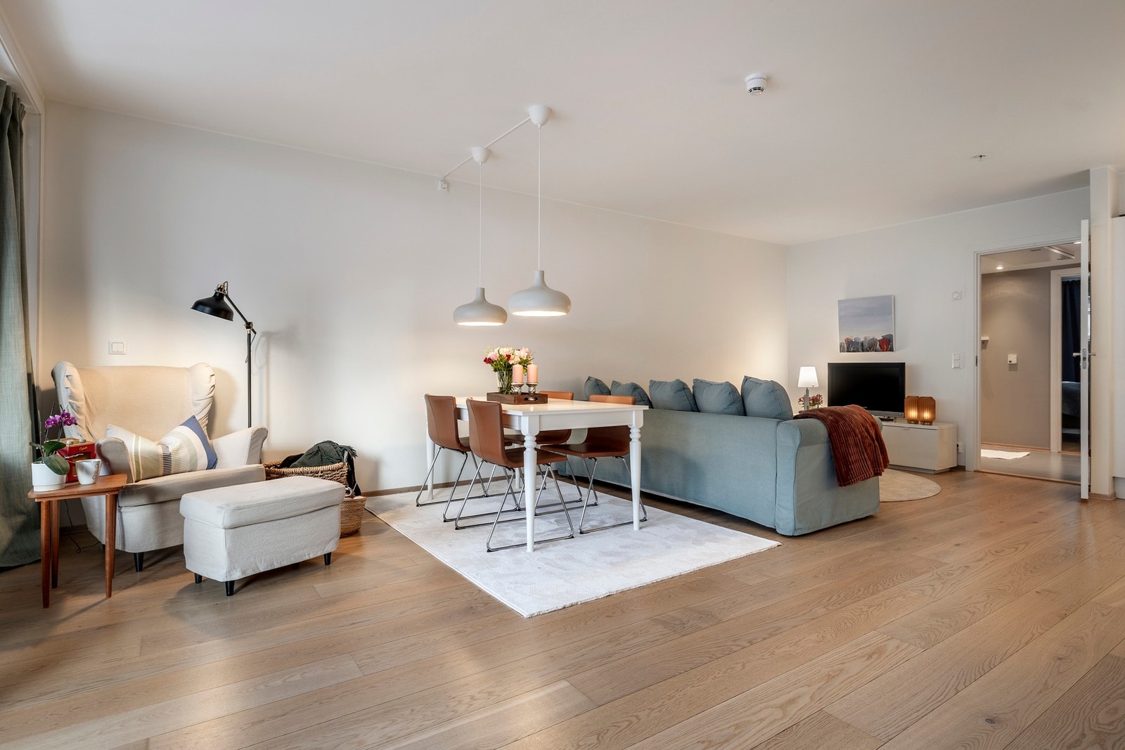 Stuen er malt i lyse fargetoner og gulvet er belagt med parkett. Galleribilde