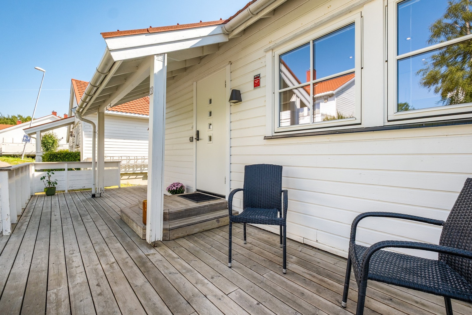 Overbygd inngangsparti med romslig terrasse - en lun og innbydende adkomst til boligen. Galleribilde