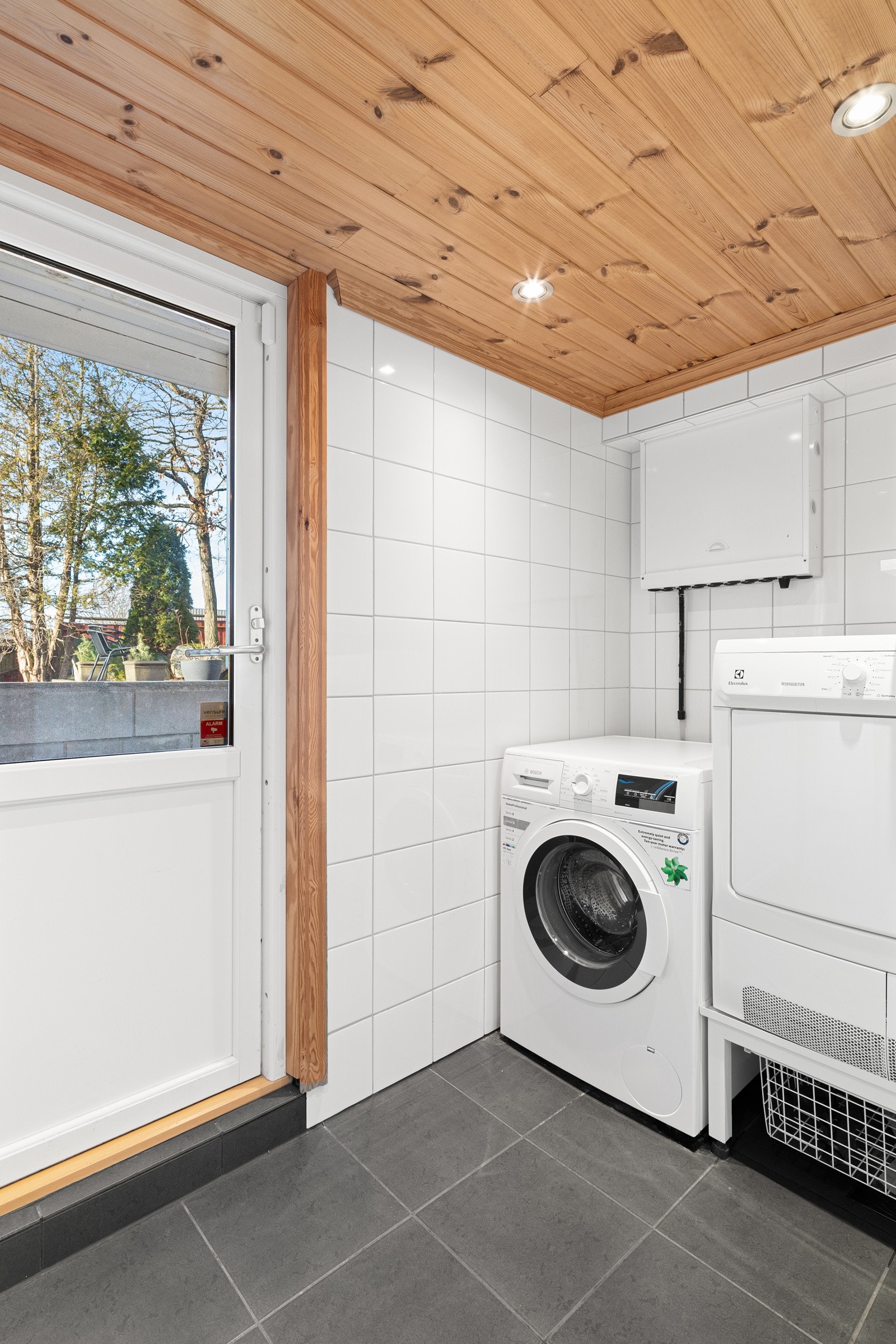 Vaskerommet ligger praktisk vegg-i-vegg med badet og fungerer samtidig som en smart bi-inngang. Her er det samme fliser som på badet, og rommet er utstyrt med opplegg for vaskemaskin. Galleribilde