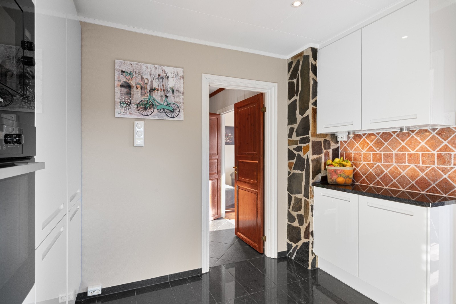 Gulvet er belagt med mørke fliser som gir en fin kontrast til vegger malt i en lys og lun beigetone. Galleribilde