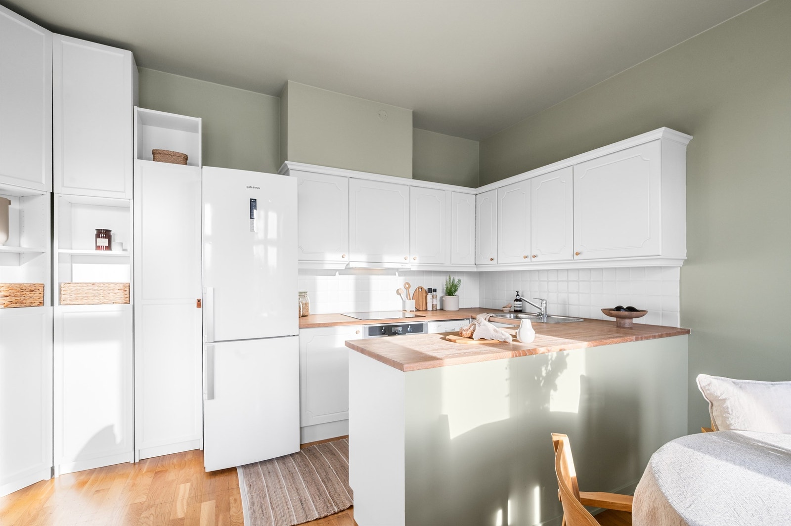 Kjøkkenet er fra ombyggingsåret med ny servantarmatur fra 2025 og nyslipt benkeplate i 2026. Innredningen består av lyse, profilerte fronter og benkeplate av heltre. Galleribilde