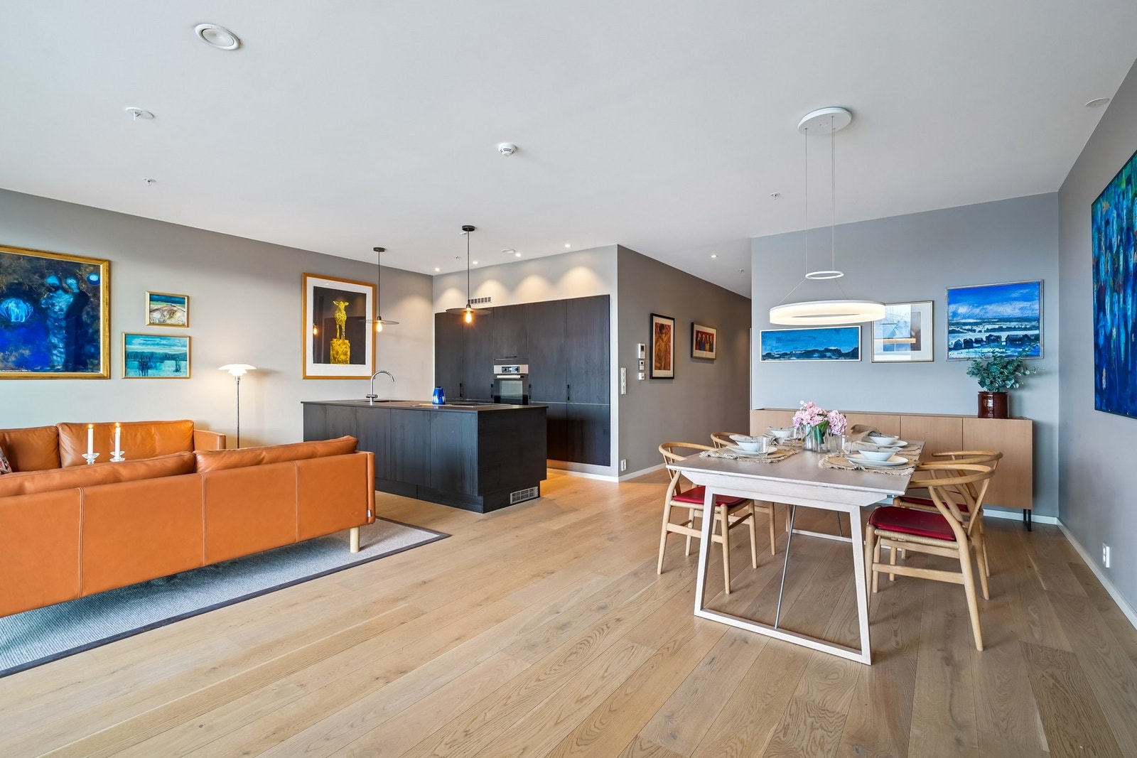 Store vinduer fra tak til gulv slipper inn rikelig med dagslys til stuen. Galleribilde