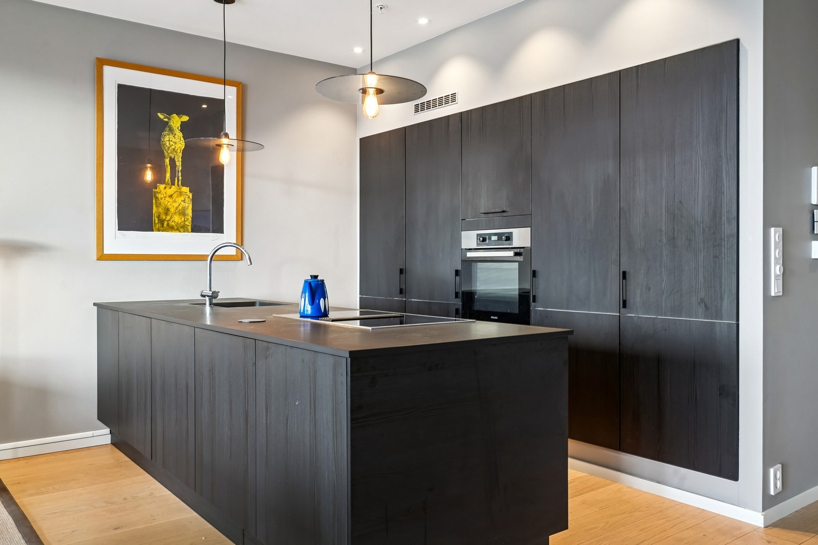 Kjøkkenet har lekker innredning fra HTH med mørke fronter og laminat benkeplate. Kjøkkenventilator med kullfilter. Galleribilde