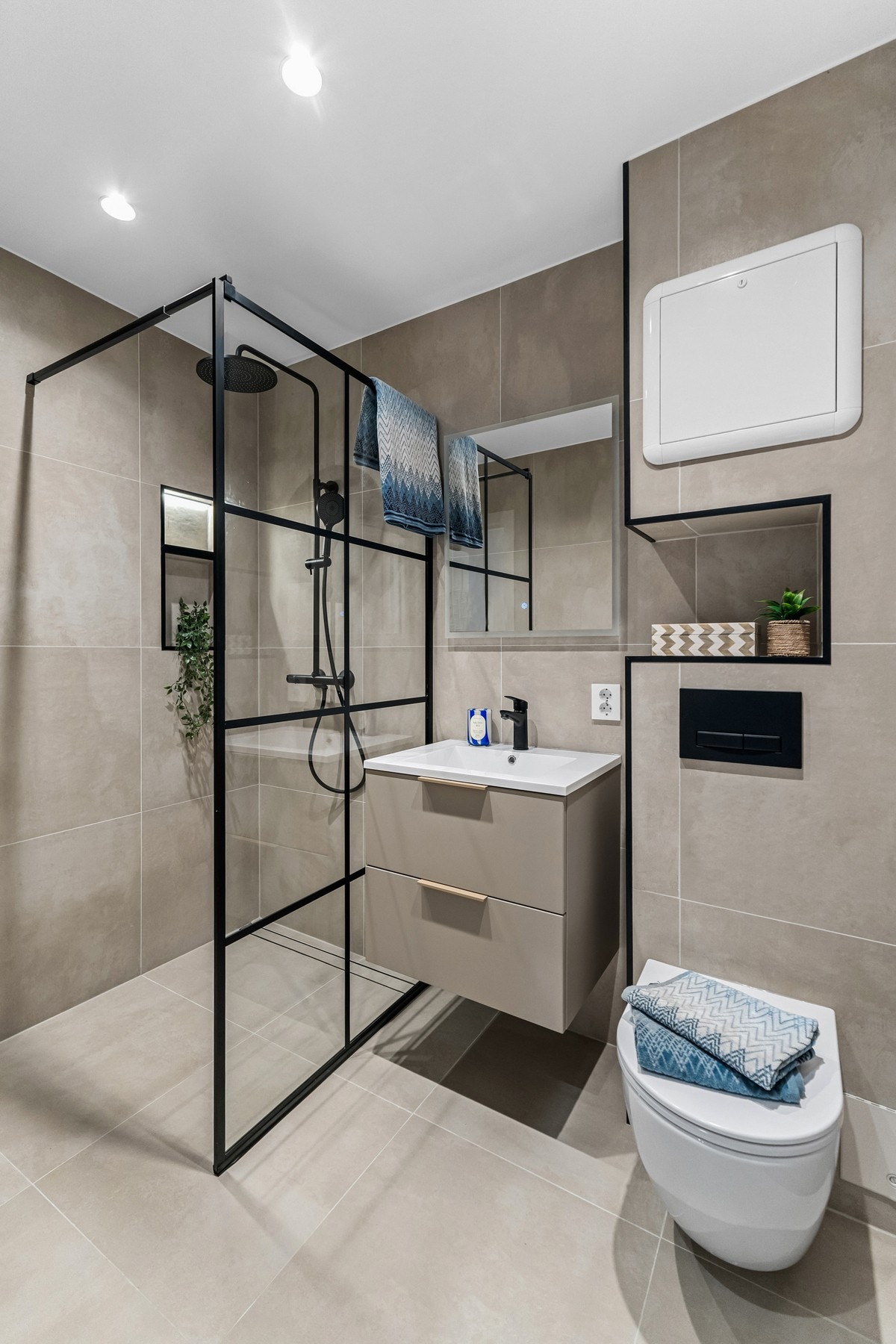 Stilrent bad med store fliser i moderne fargevalg, flislagt Purus sluk, regnfallsdusj og gjennomførte detaljer Galleribilde