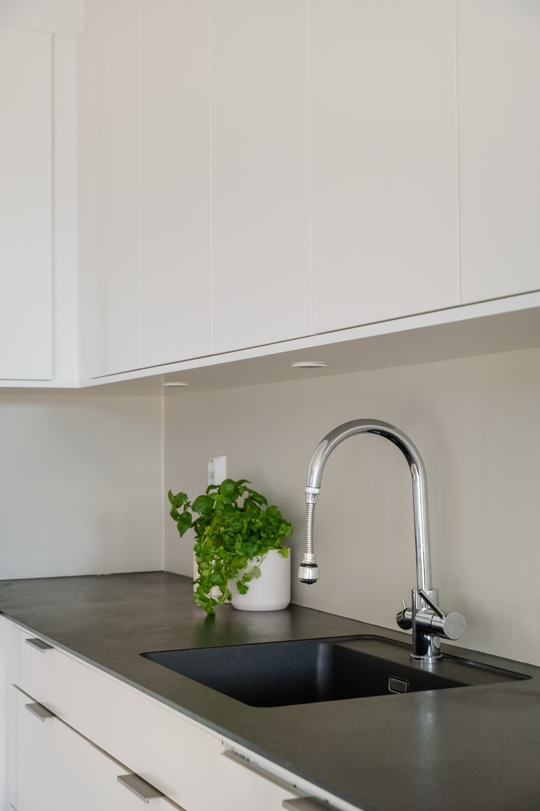 Det er lys montert mellom overskapene og benken. Galleribilde