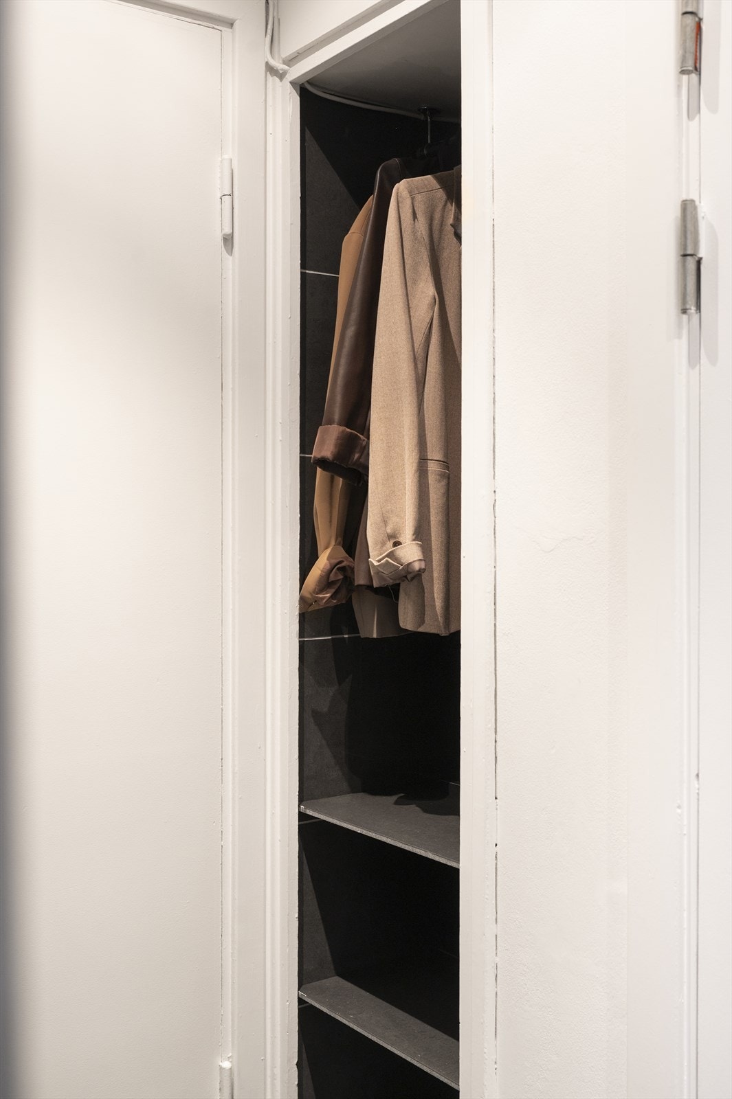 I tillegg til skyvedørsgarderobe har entréen et praktisk, integrert skap som gir ekstra plass til oppbevaring av yttertøy. Galleribilde