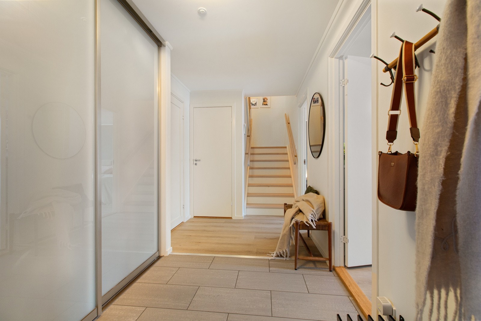 Fra en utvendig trapp kommer vi opp til andre etasje og leilighetens hyggelige entré. Entréen har flislagt gulv med varmekabler, og er praktisk innredet med skyvedørsgarderobe som gir godt med plass til yttertøy og sko. Galleribilde