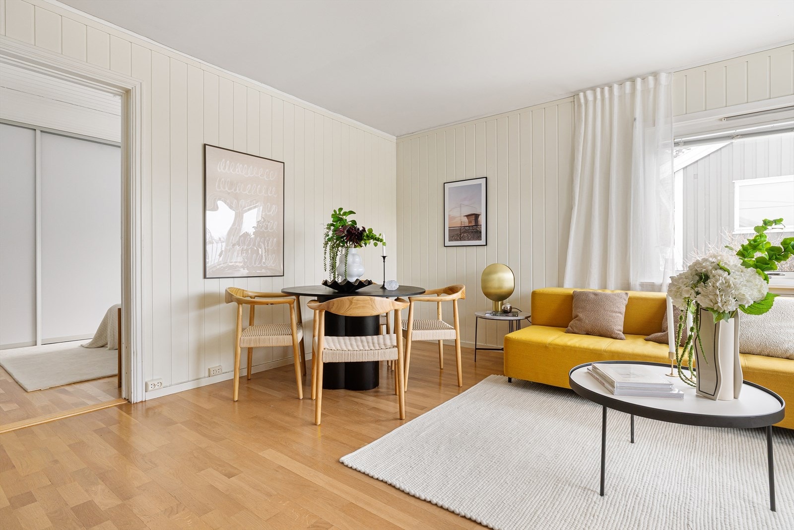 Det er pent panel på veggene, og plass til både sofa og spiseområde. Galleribilde